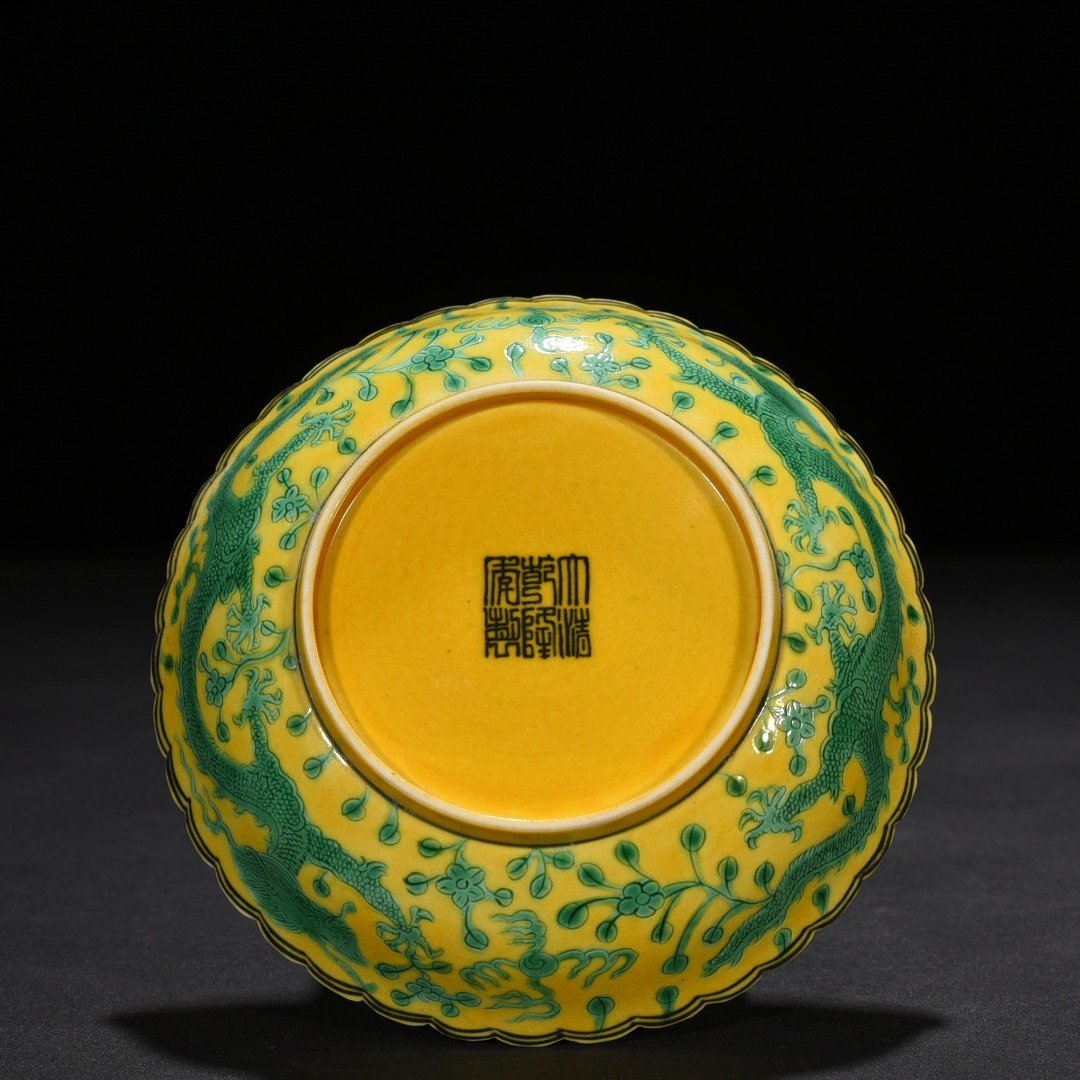 Qing Dynasty Qianlong plain three-color yellow ground engraved five-dragon sunflower mouth plate