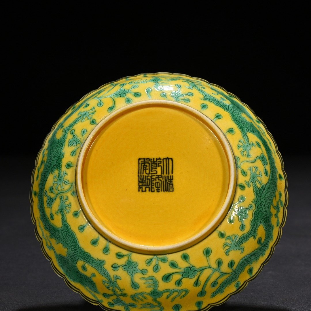 Qing Dynasty Qianlong plain three-color yellow ground engraved five-dragon sunflower mouth plate