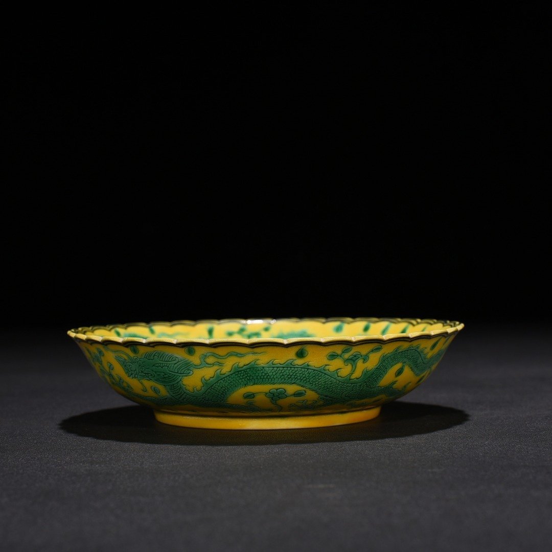 Qing Dynasty Qianlong plain three-color yellow ground engraved five-dragon sunflower mouth plate