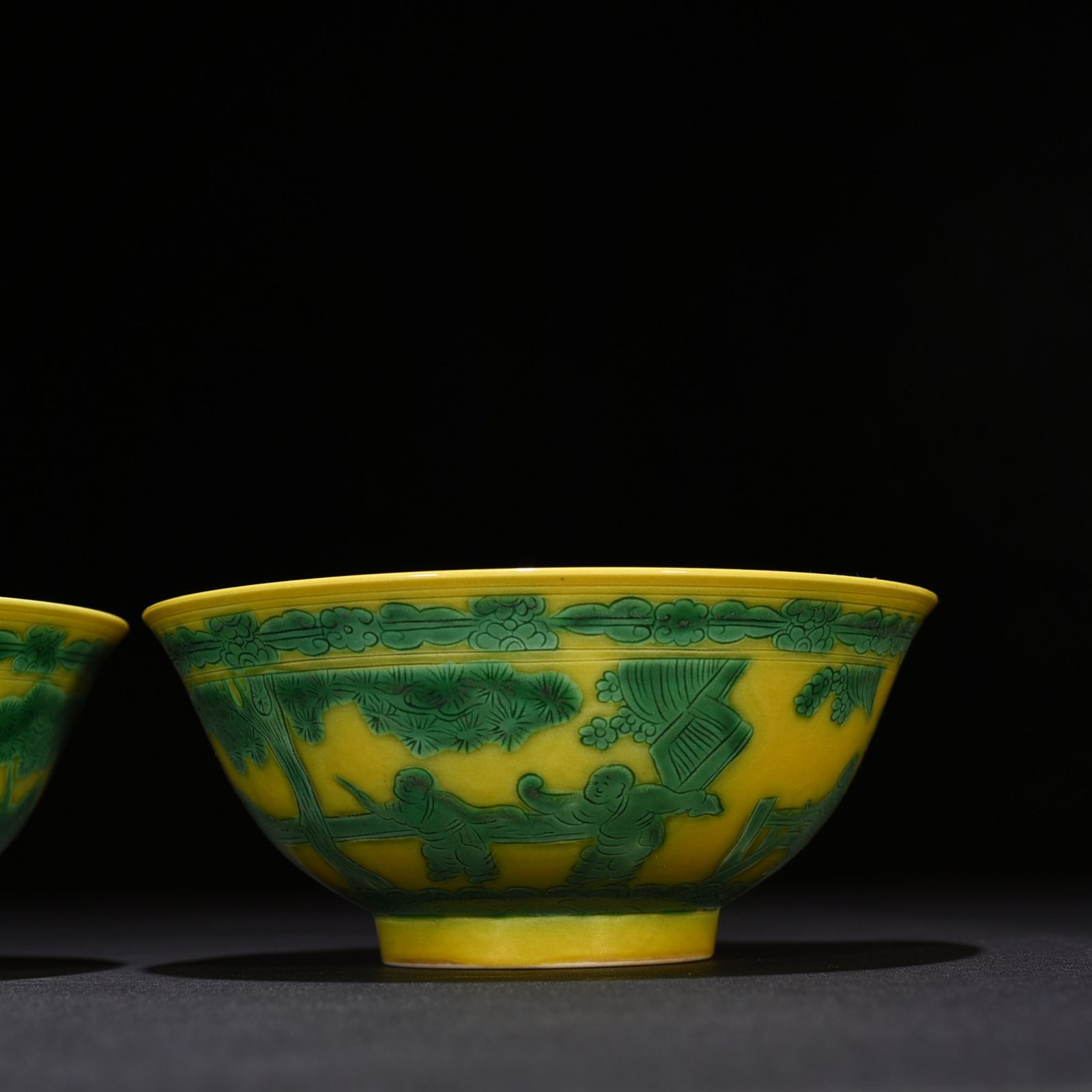 Qing Dynasty Kangxi yellow glaze engraved green color baby playing bowl