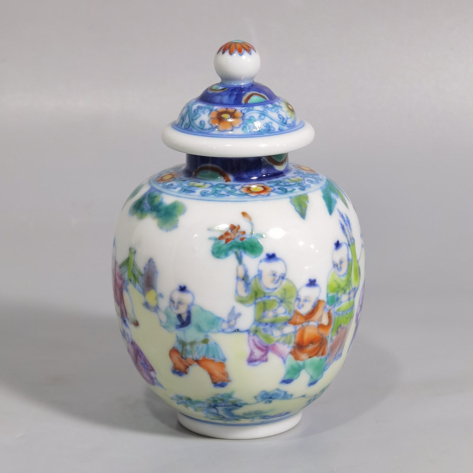 Qing Dynasty Qianlong blue and white colored baby playing picture covered jar