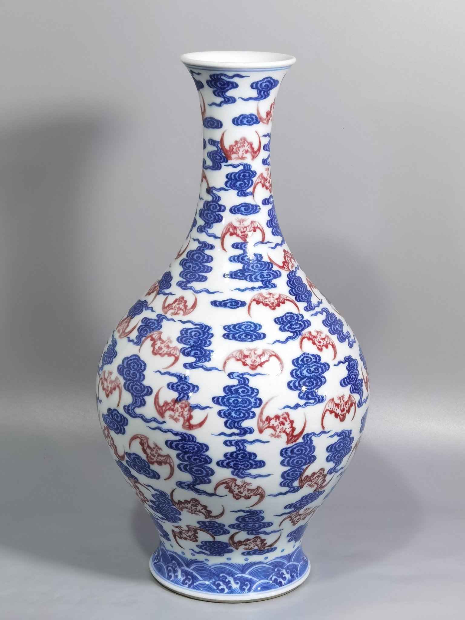 Qing Dynasty Qianlong blue and white underglaze red cloud bat pattern olive vase