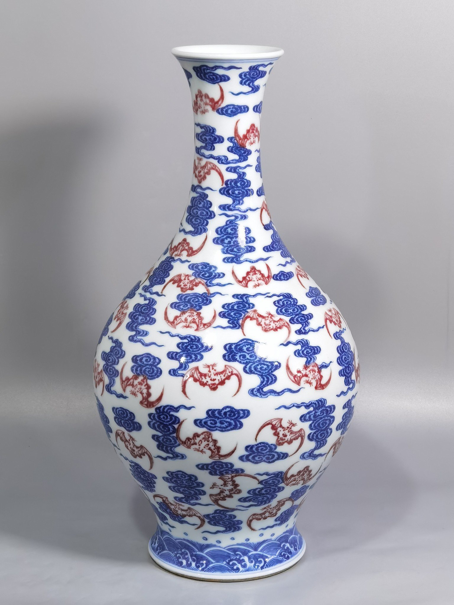 Qing Dynasty Qianlong blue and white underglaze red cloud bat pattern olive vase