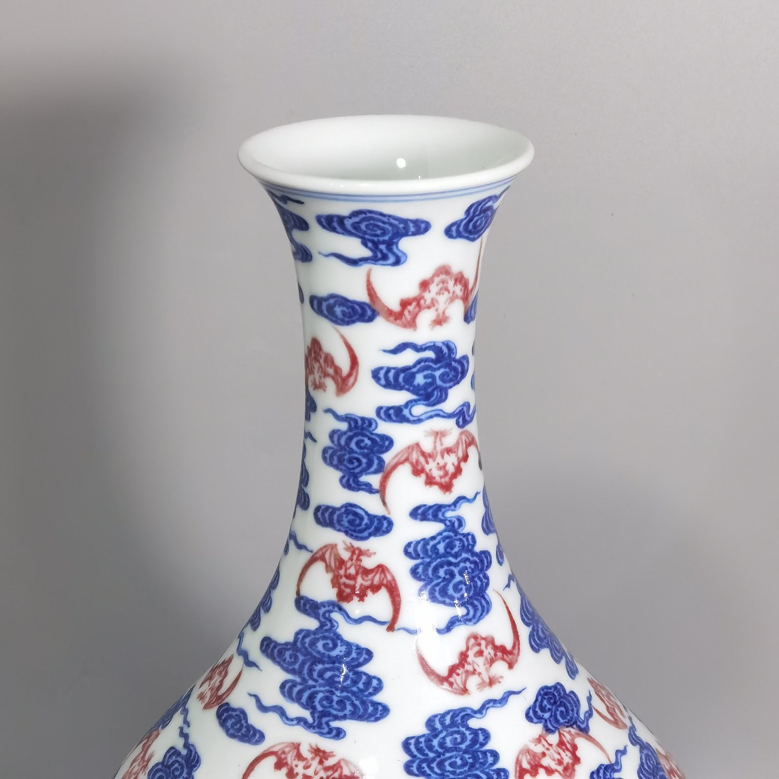 Qing Dynasty Qianlong blue and white underglaze red cloud bat pattern olive vase