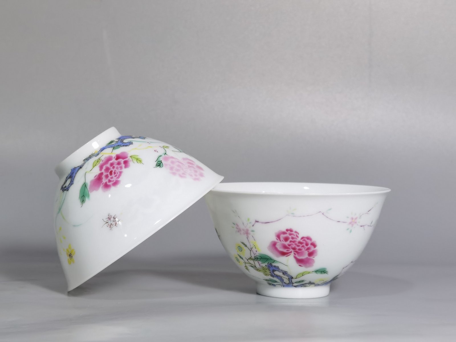 Qing Dynasty Yongzheng pair of tea circles with pastel peonies and poems