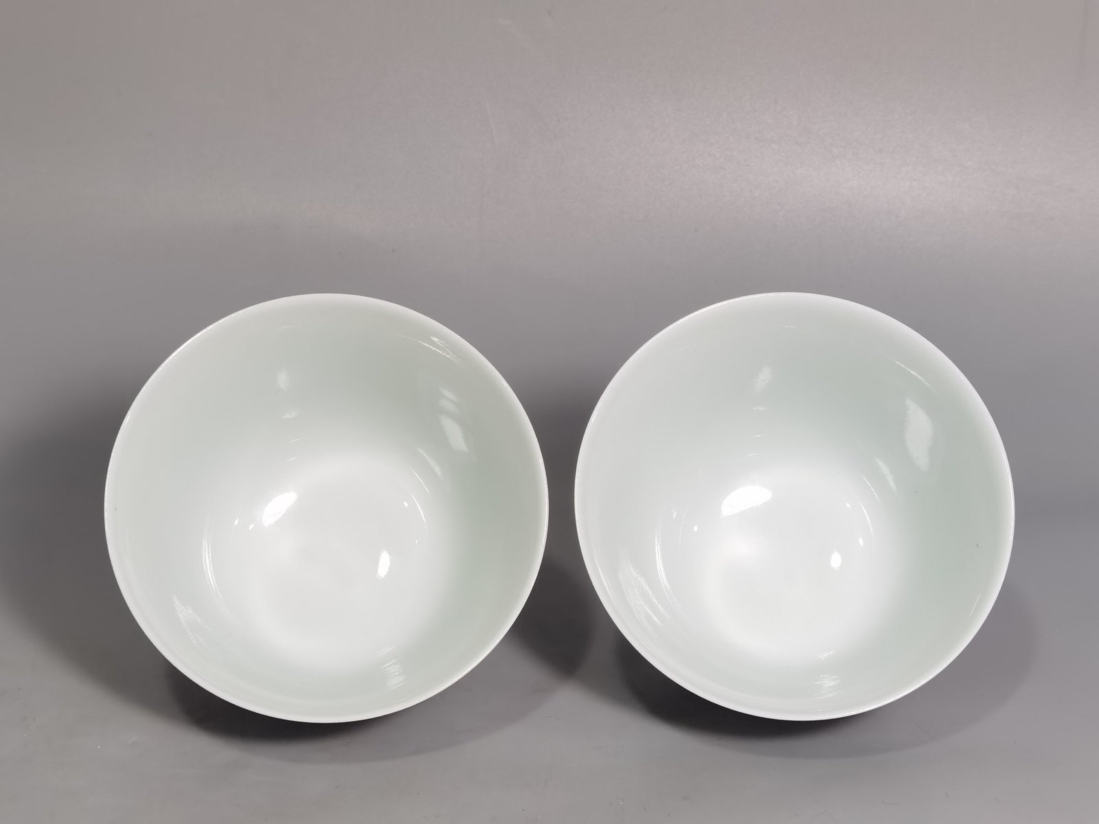 Qing Dynasty Yongzheng pair of pastel-painted boys presenting peaches and poems with tea balls