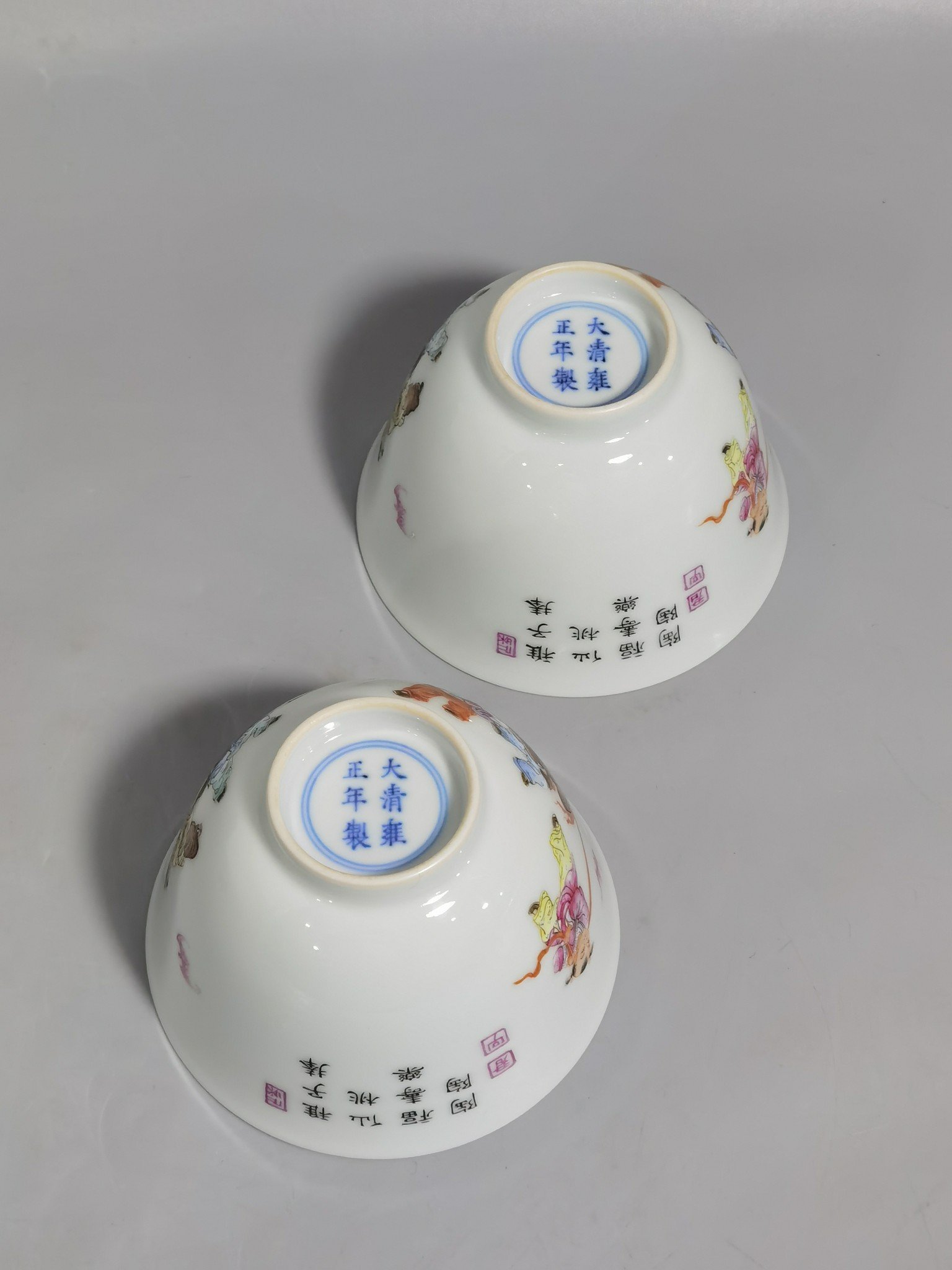 Qing Dynasty Yongzheng pair of pastel-painted boys presenting peaches and poems with tea balls