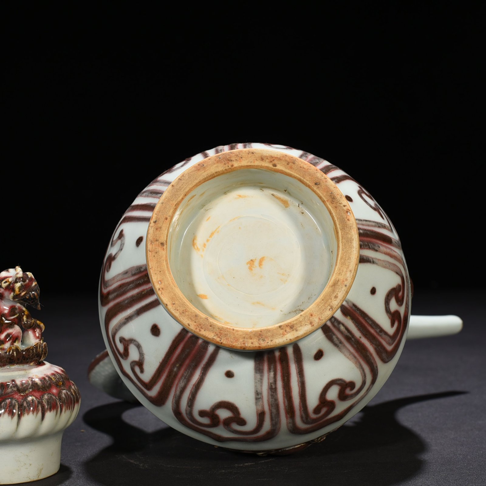 Yuan Dynasty underglaze red embossed lion rolling hydrangea and holding a pot