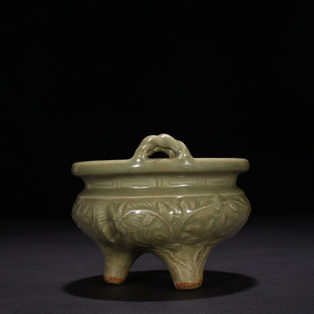 Song Dynasty Longquan kiln plum green glaze carved with branches and flowers pattern three-legged stove
