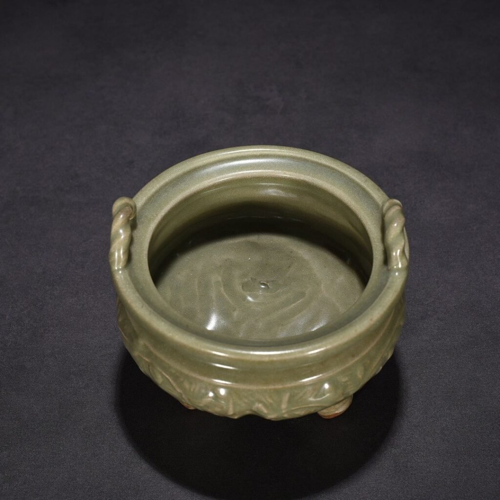 Song Dynasty Longquan kiln plum green glaze carved with branches and flowers pattern three-legged stove