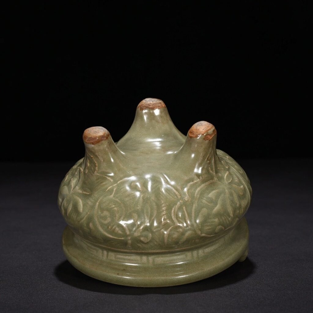 Song Dynasty Longquan kiln plum green glaze carved with branches and flowers pattern three-legged stove
