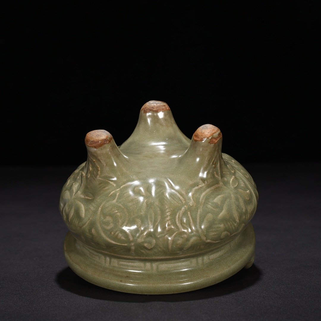 Song Dynasty Longquan kiln plum green glaze carved with branches and flowers pattern three-legged stove