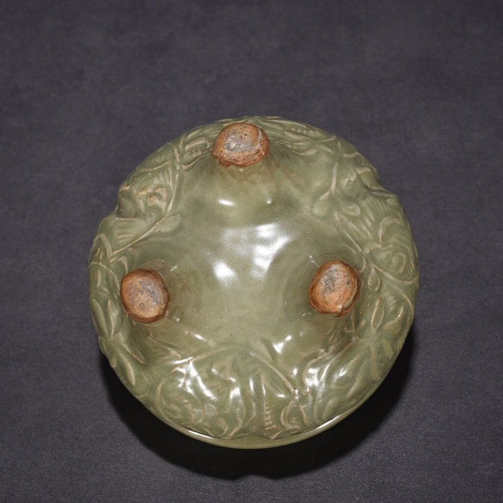 Song Dynasty Longquan kiln plum green glaze carved with branches and flowers pattern three-legged stove