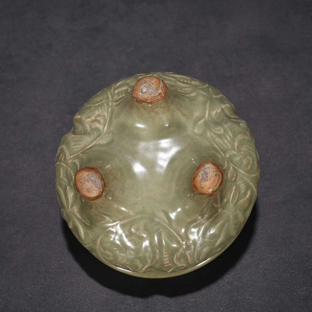 Song Dynasty Longquan kiln plum green glaze carved with branches and flowers pattern three-legged stove