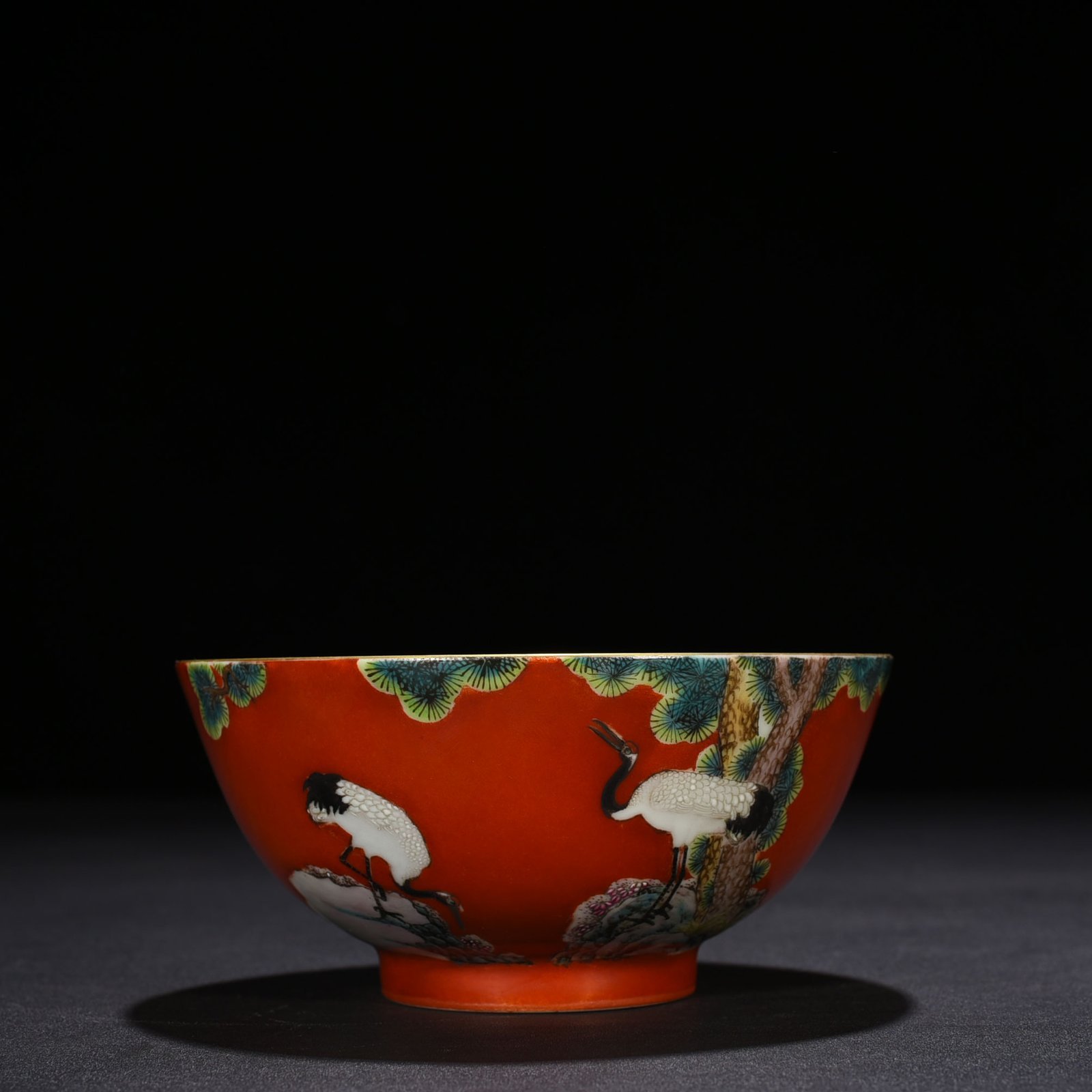 Qing Dynasty Qianlong alum red ground pastel pine and crane longevity pattern bowl