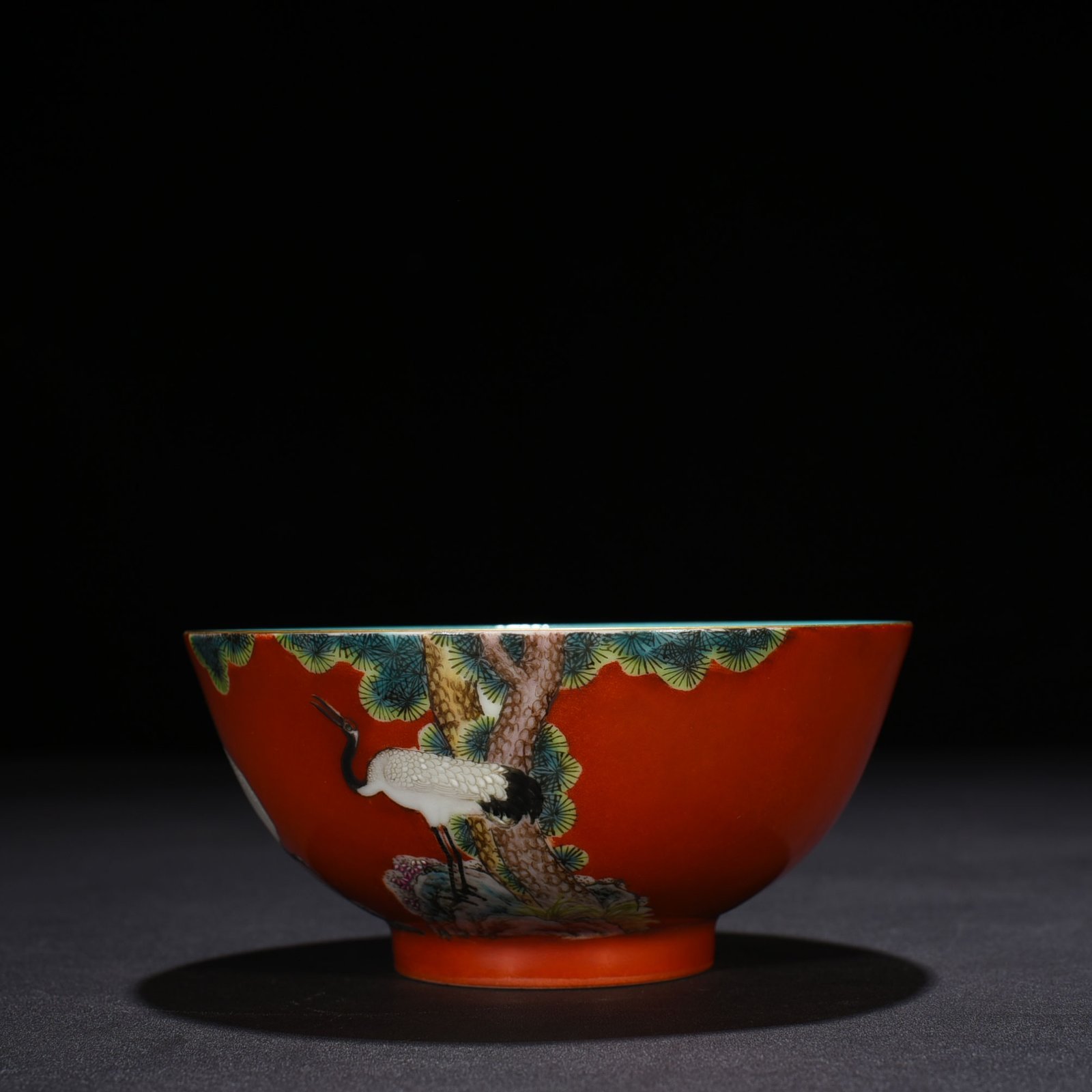 Qing Dynasty Qianlong alum red ground pastel pine and crane longevity pattern bowl