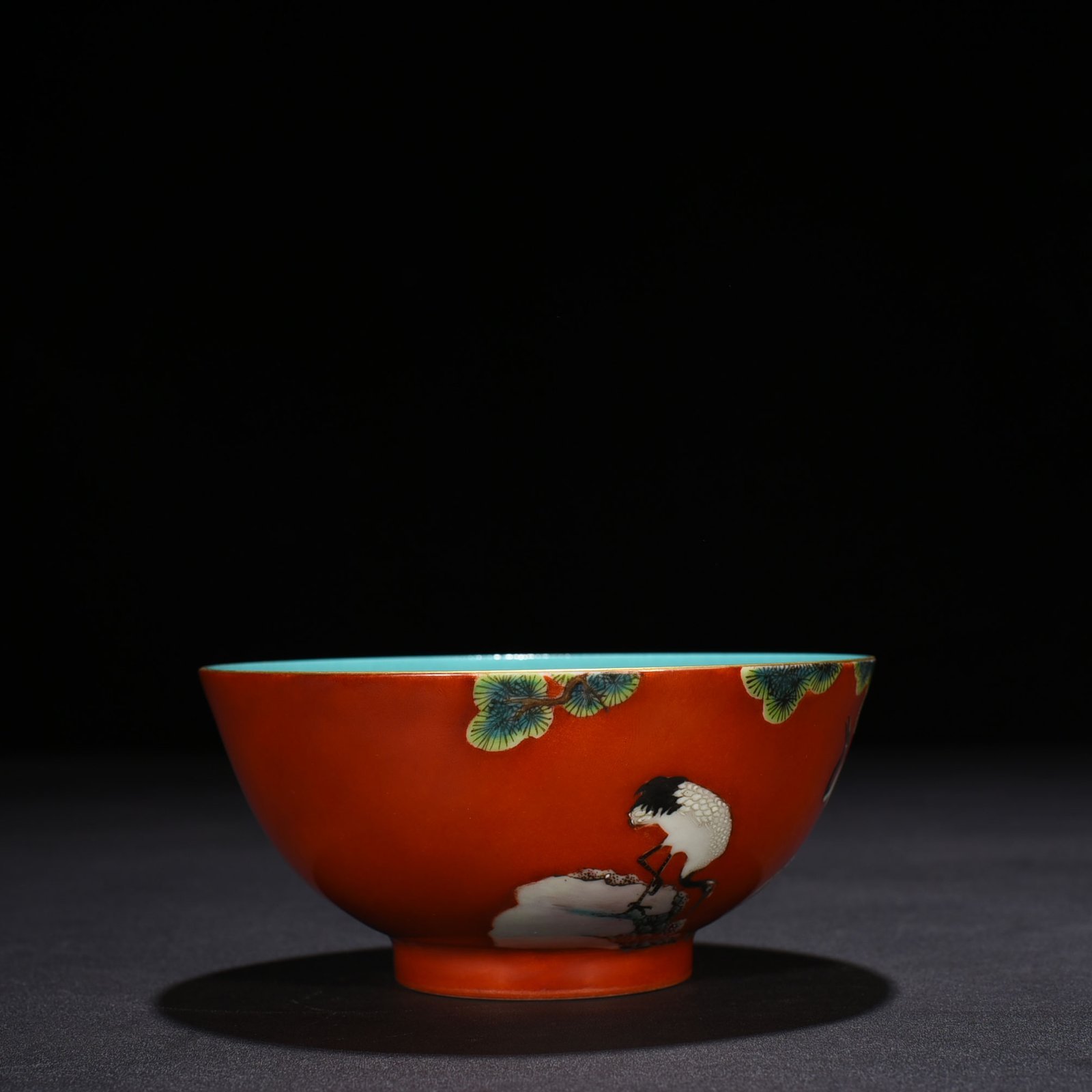 Qing Dynasty Qianlong alum red ground pastel pine and crane longevity pattern bowl