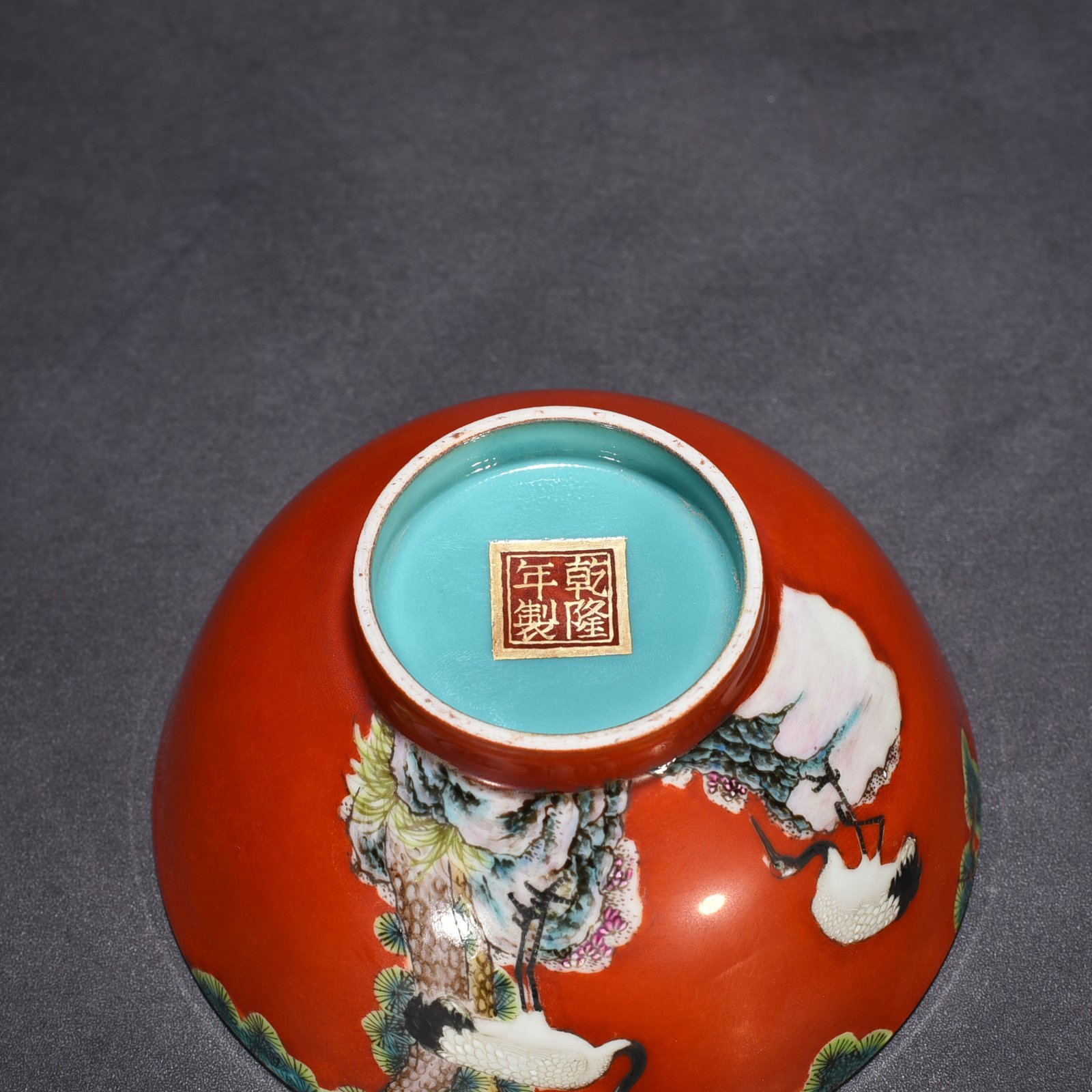 Qing Dynasty Qianlong alum red ground pastel pine and crane longevity pattern bowl